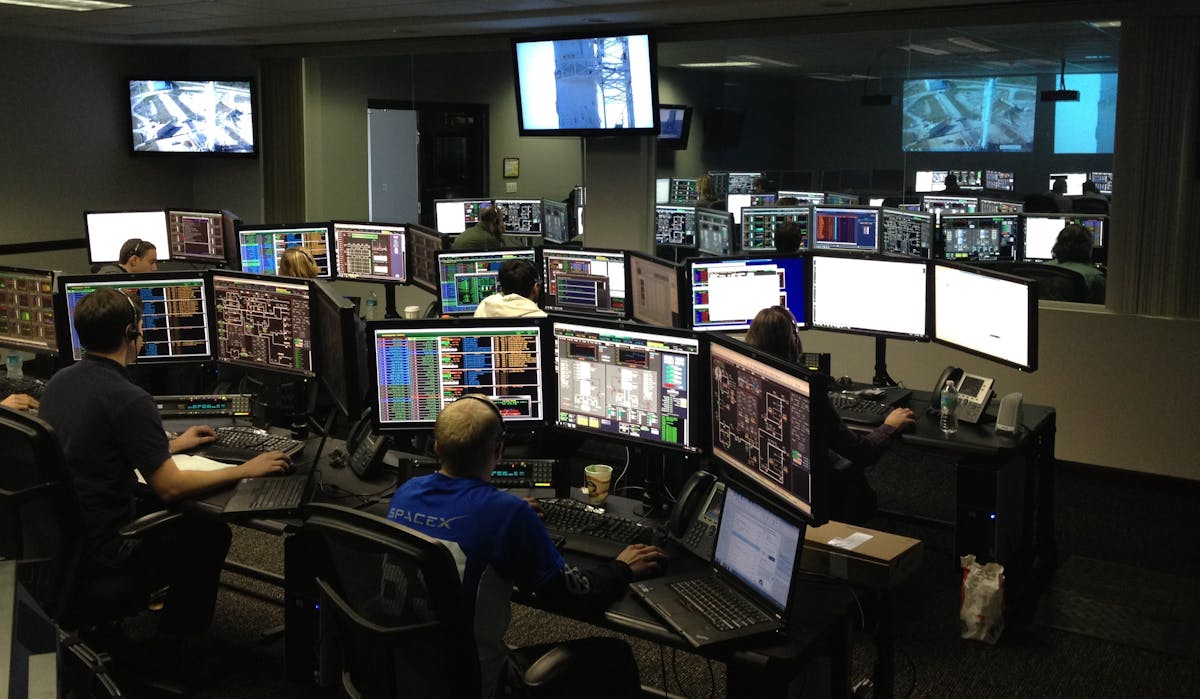 Operations team working in a monitoring room with many computer displays